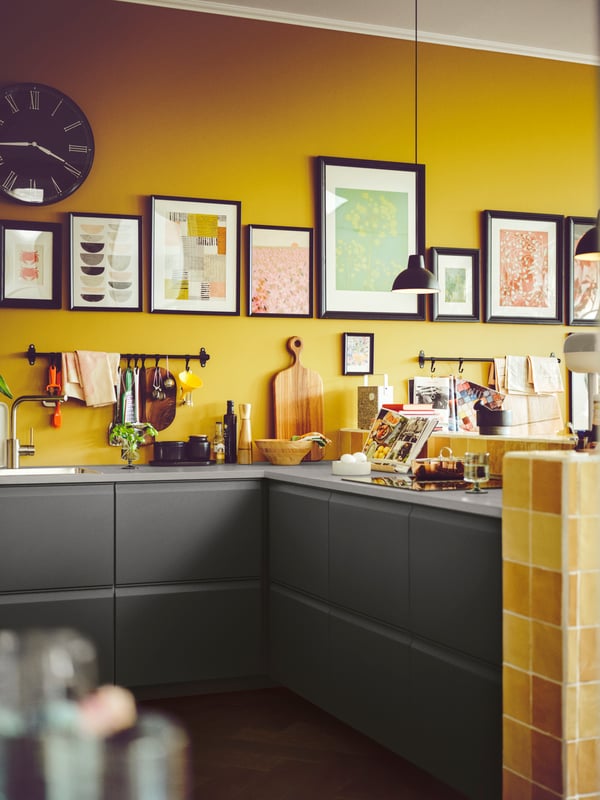 Le coin d'une cuisine contient des tiroirs UPPLÖV et un comptoir gris clair sur lequel on retrouve des pots, des livres de recettes, un bol et une planche à découper.