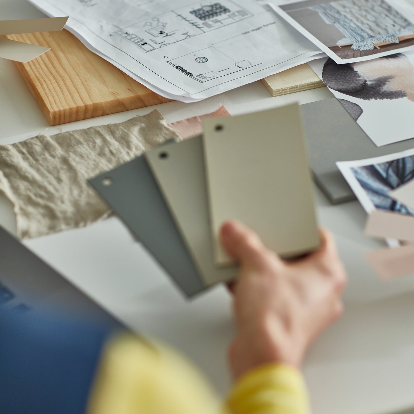 A woman with yellow and blue working attire watching three color swatch.