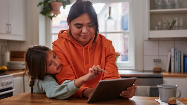 A mother and her daughter look at a tablet with a smile and look at the IKEA Family Newsletter
