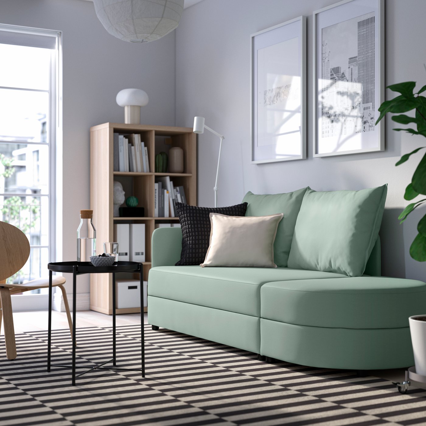 A Vissle light grey-green LINDÅKRA 2-seat sofa-bed in the living room