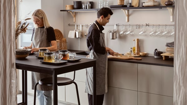 Two people working in a kitchen.