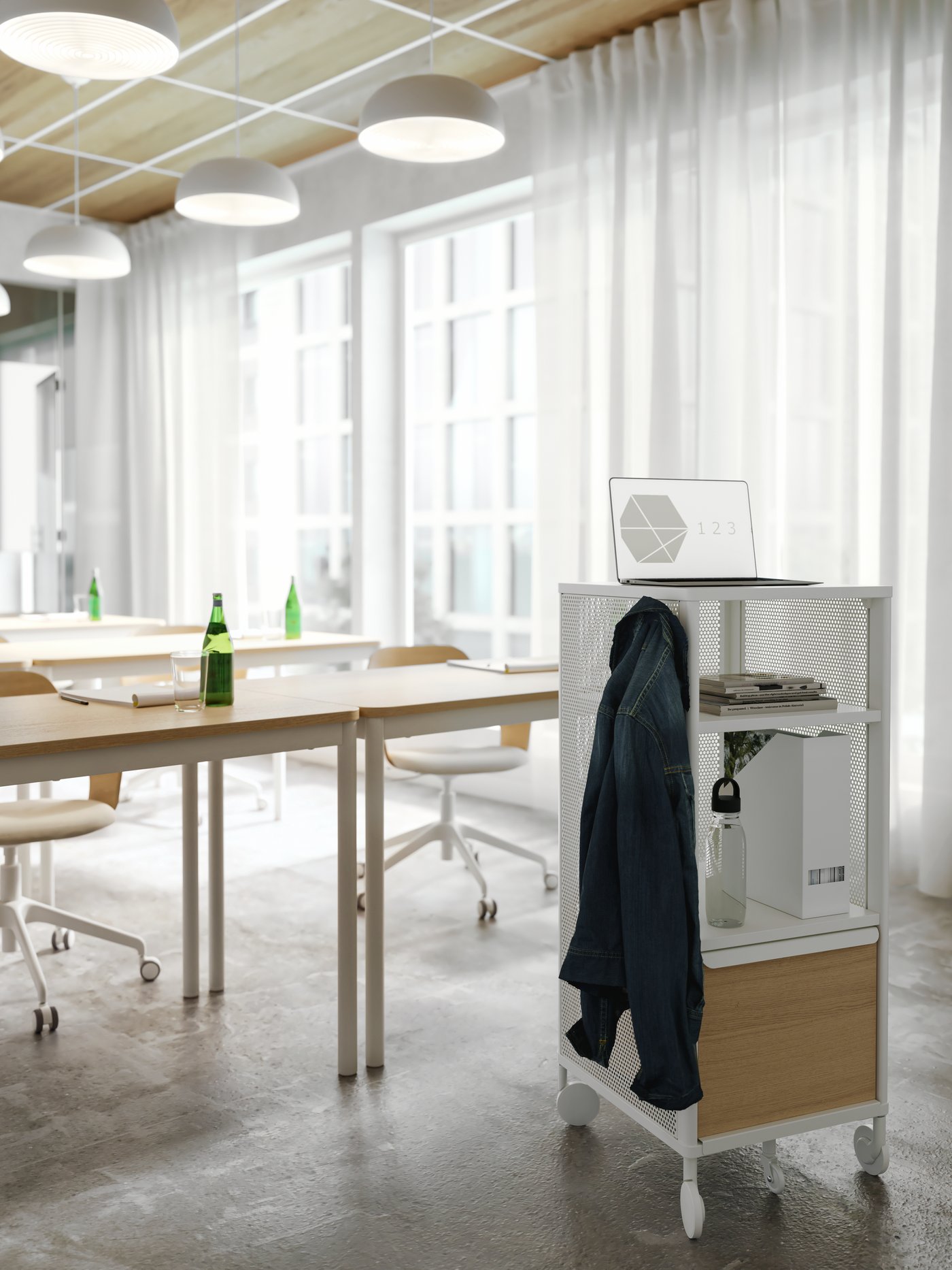 A white storage unit on castors used as a presentation stand in a conference room. A jacket hangs on a hook on its side.