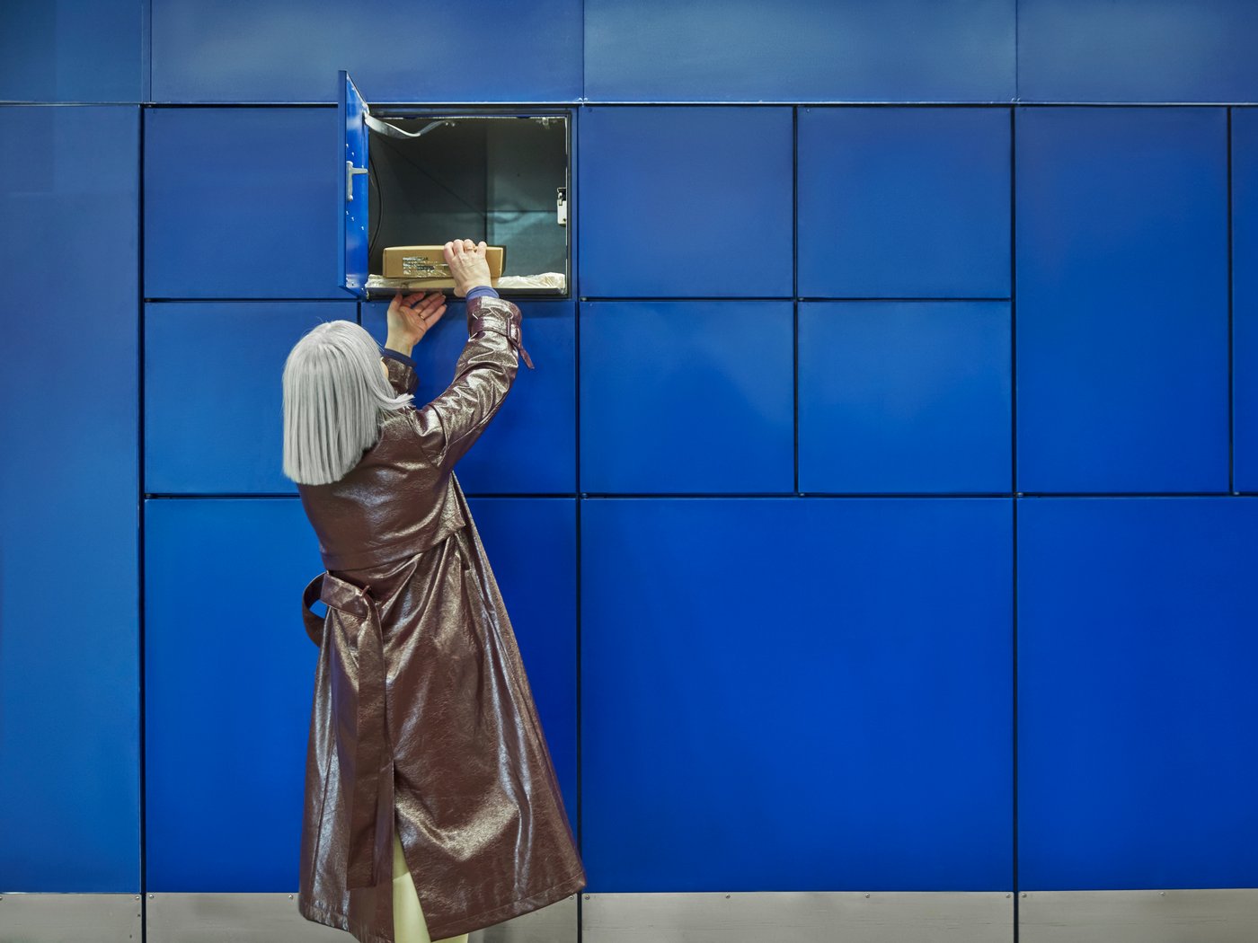 žena s šedivými vlasy vyzvedávající z ikea boxu