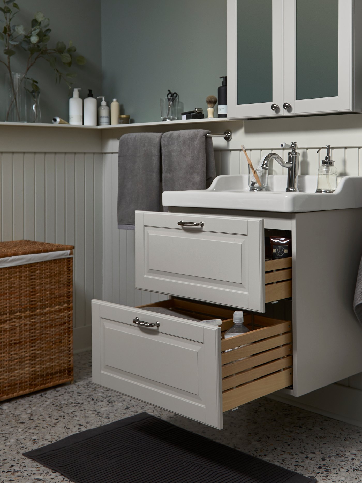 A light grey/white GODMORGON/RÄTTVIKEN wash-stand/wash-basin with two spacious open drawers and a mirror cabinet above.
