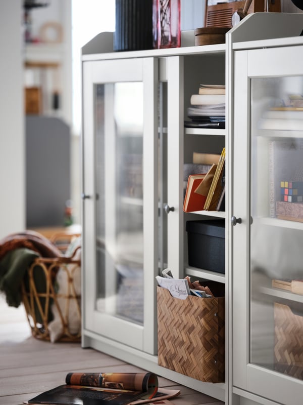 Vitrina HAUGA con libros y cajas en su interior.