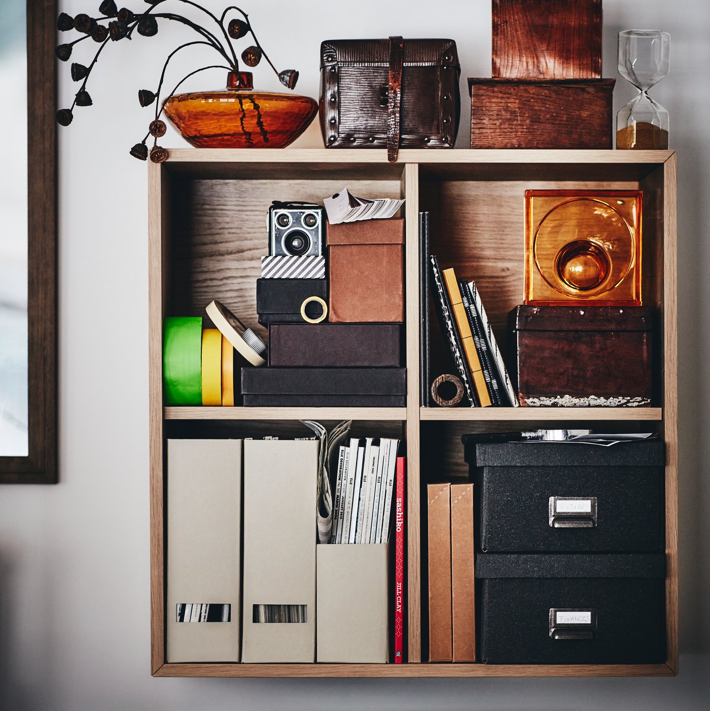 EKET wall-mounted shelf unit with white stained oak effect filled with files and storage boxes.