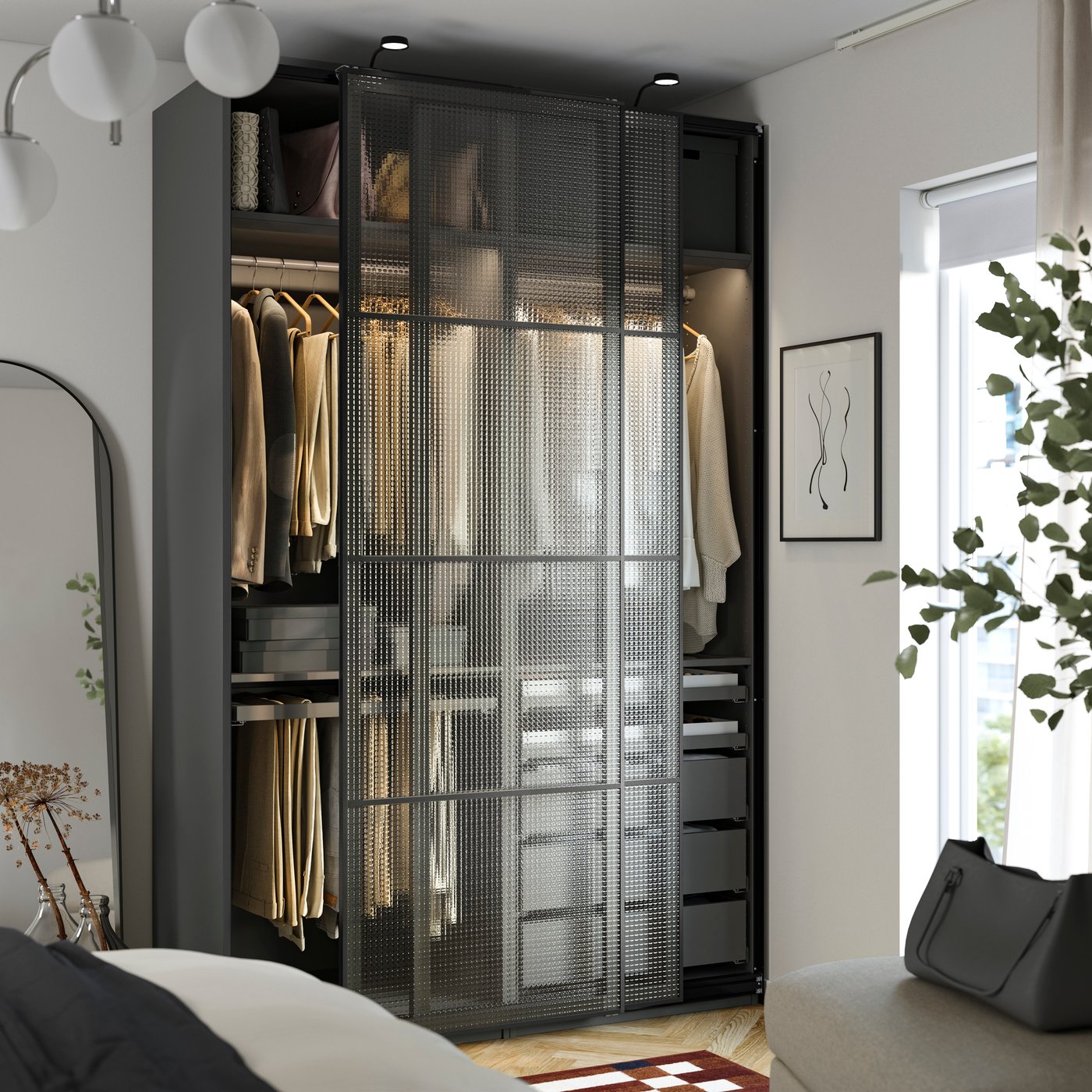 A PAX / LUNDBRÄSMA wardrobe with sliding doors and light grey KOMPLEMENT inserts with compartments in the bedroom.
