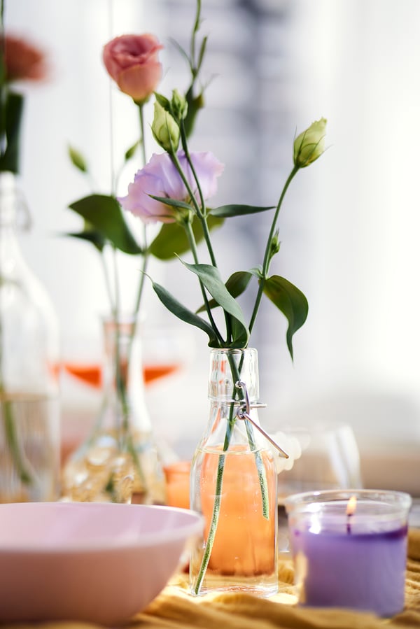Close-up of a small swing-bottle with three flowers in it