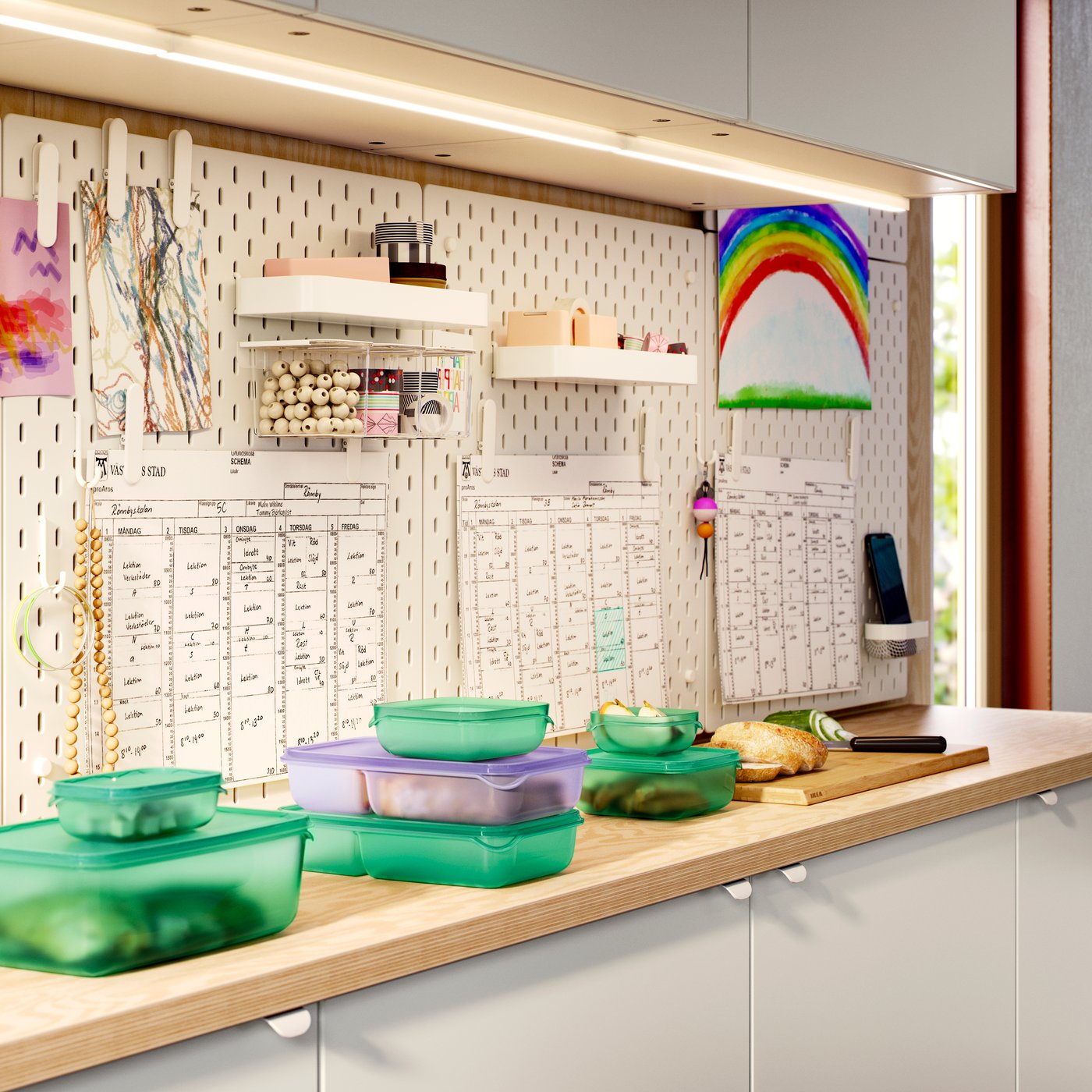 Kitchen work surfaces with EKBACKEN worktop with lots of PRUTA sandwich containers, and SKÅDIS pegboards with trays hanging.