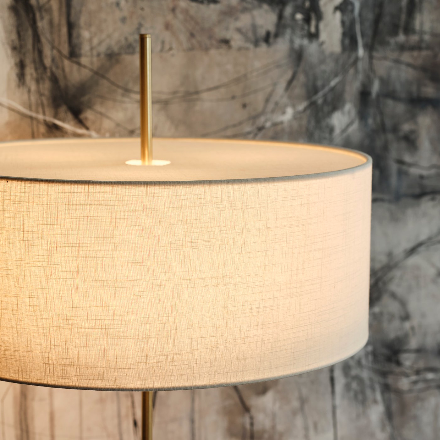 Närbild av en vit textil-/mässingspläterad STOCKHOLM 2025 golvlampa.