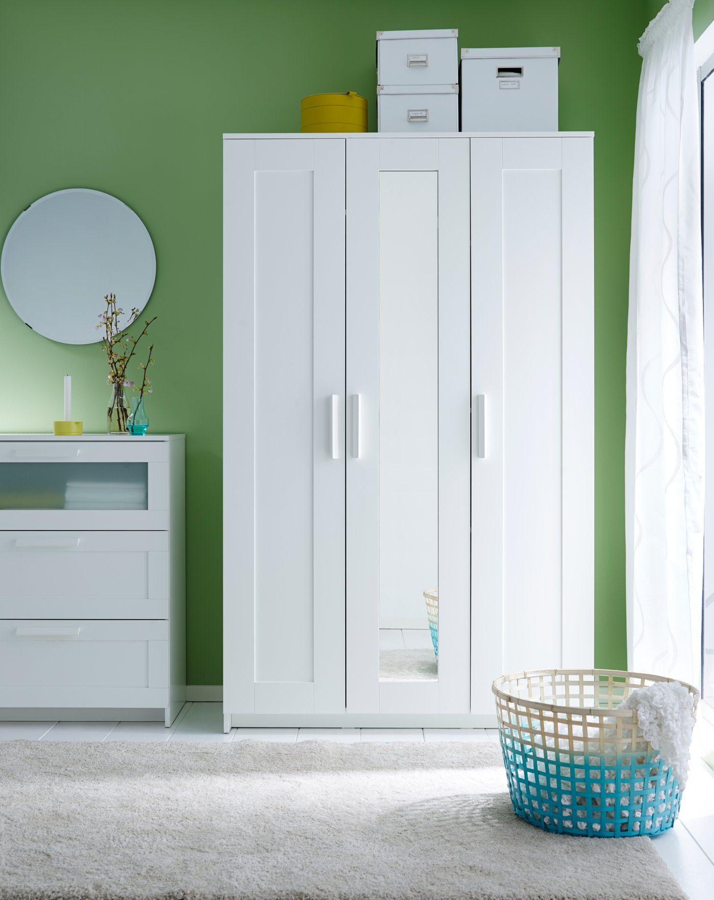 Una habitación con paredes verdes en las que destava una cómoda blanca y un clóset BRIMNES blanco.