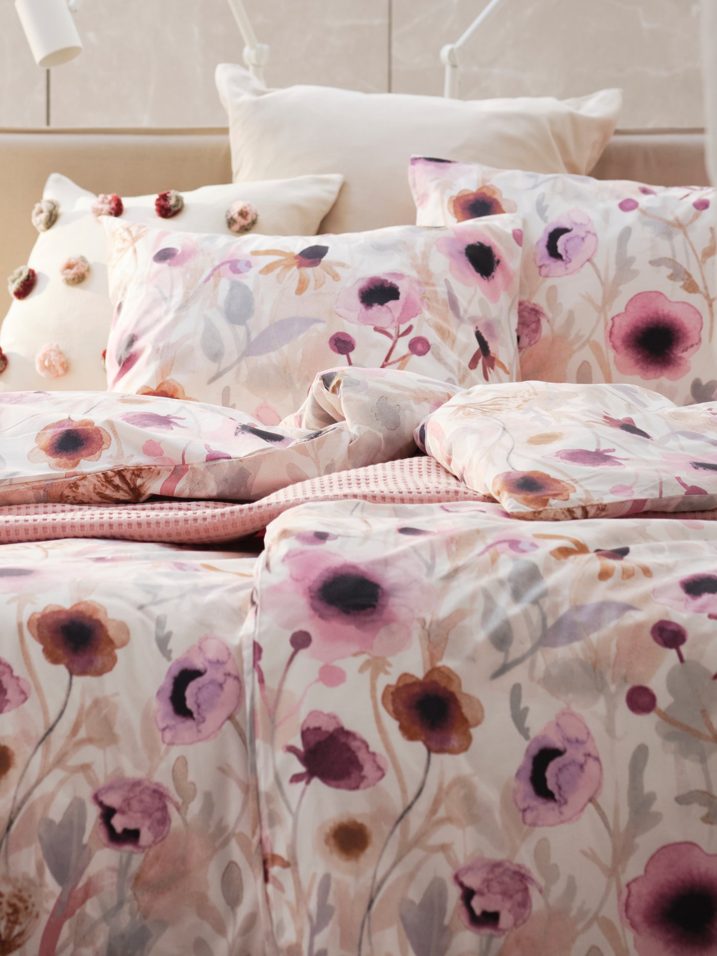 Una funda de plumón con diseño floral en tonos rosas y moras.