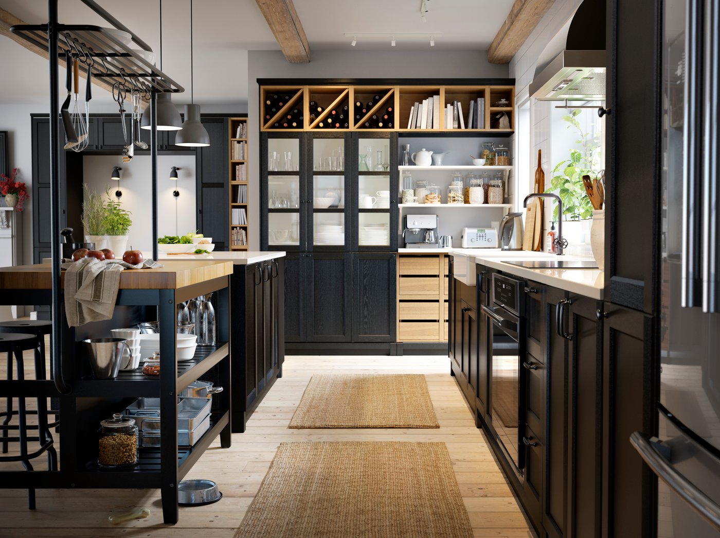A black kitchen with a wooden floor, a black kitchen island, black cabinets and wine stored on open shelves.
