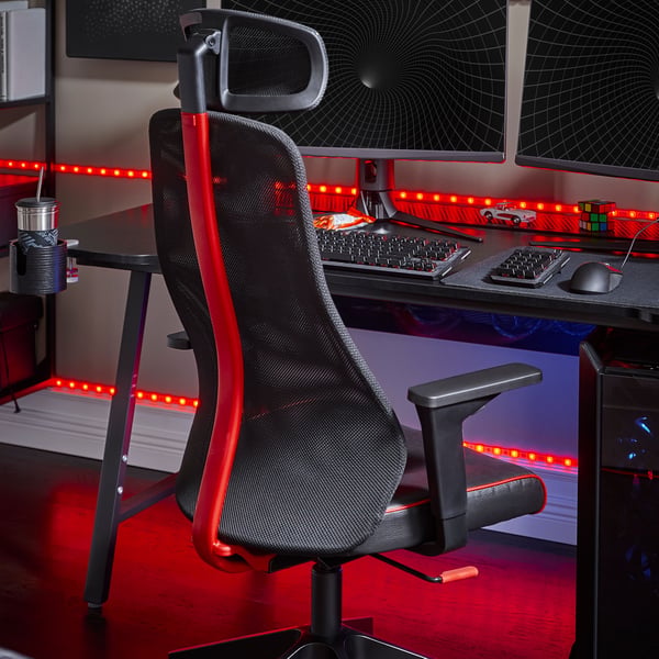 En gamingstation med svarta möbler och röda detaljer och röda LED-ljus.