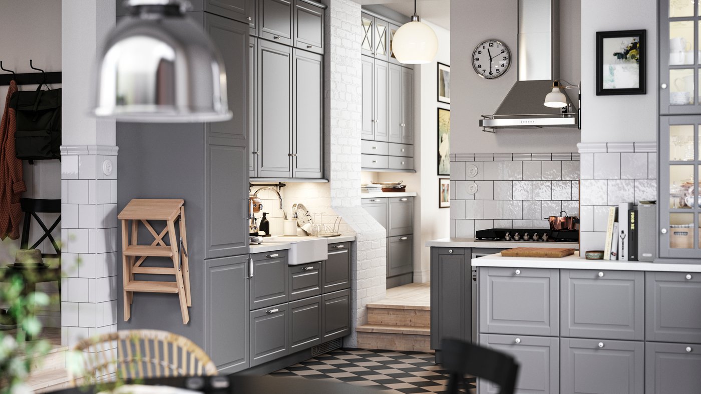 A traditional kitchen with a chequered floor, gray BODBYN kitchen fronts and white/light gray stone effect/laminate worktops.