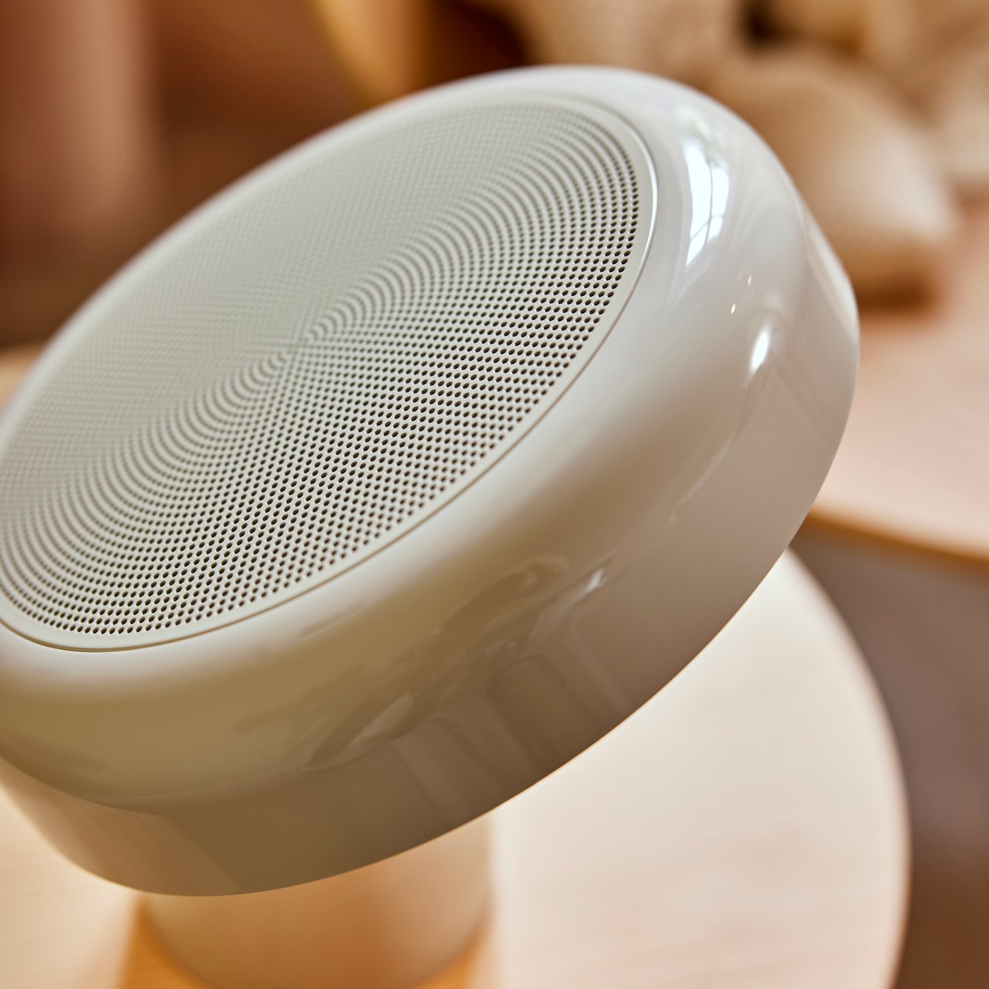 Närbild på ovansidan av en BLOMPRAKT Bluetooth-högtalare med lampa på ett STOCKHOLM 2025 sidobord.