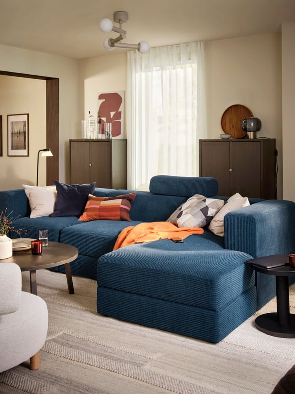 A dark blue SANELA cushion cover in the living room on a JÄTTEBO blue sofa.