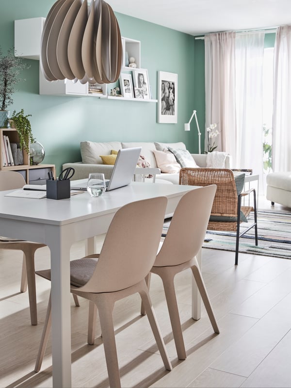 A beige SKYMNINGEN pendant lamp in the dining room
