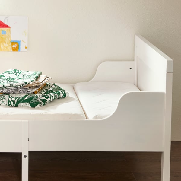 A white extendable SUNDVIK bed with a VIMSIG foam extendable mattress on it and SKOGSDUVA bed linen folded on top.