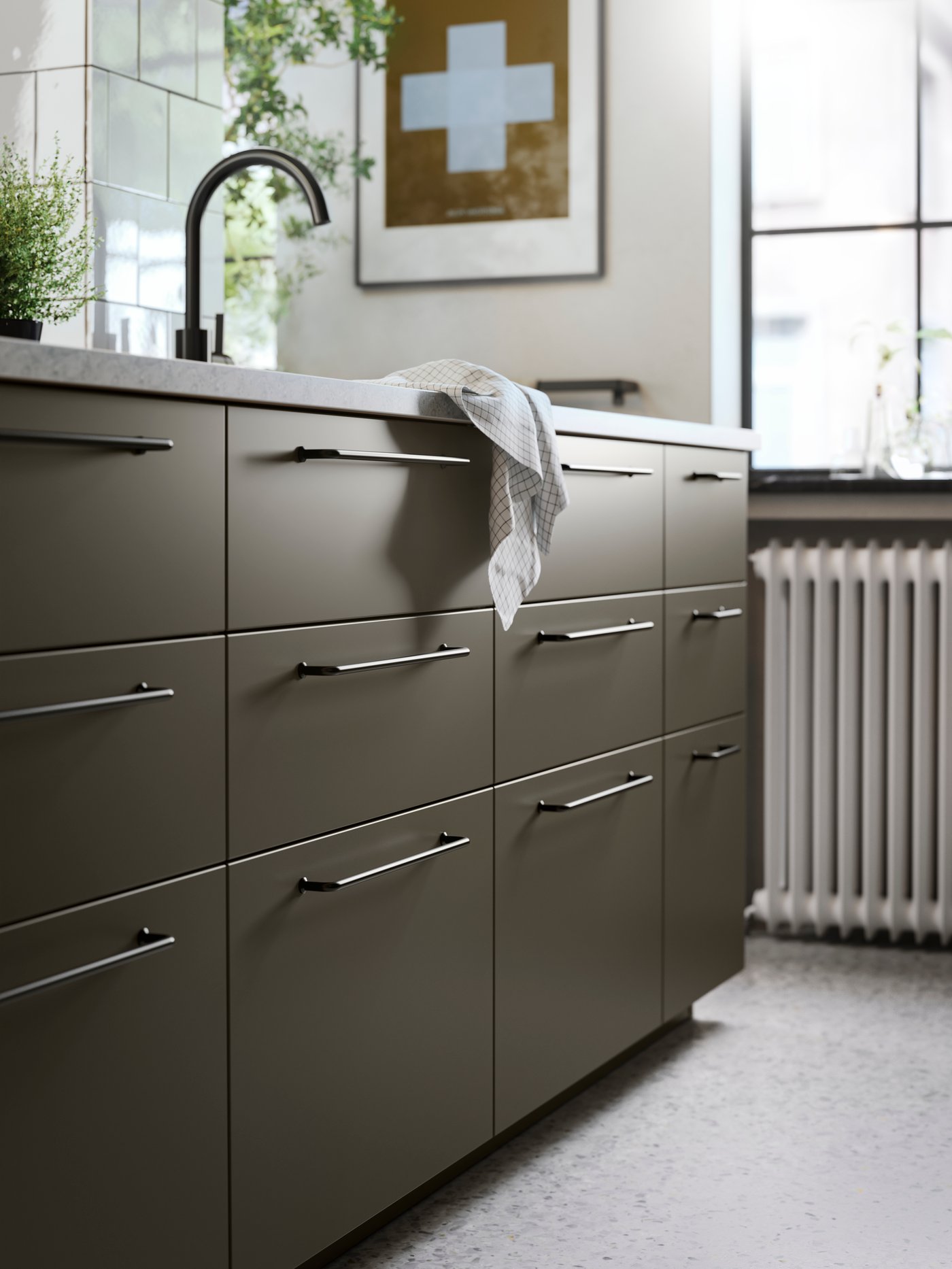A kitchen island with brown-beige HAVSTORP kitchen fronts, black handles, a limestone effect worktop and a black kitchen tap.