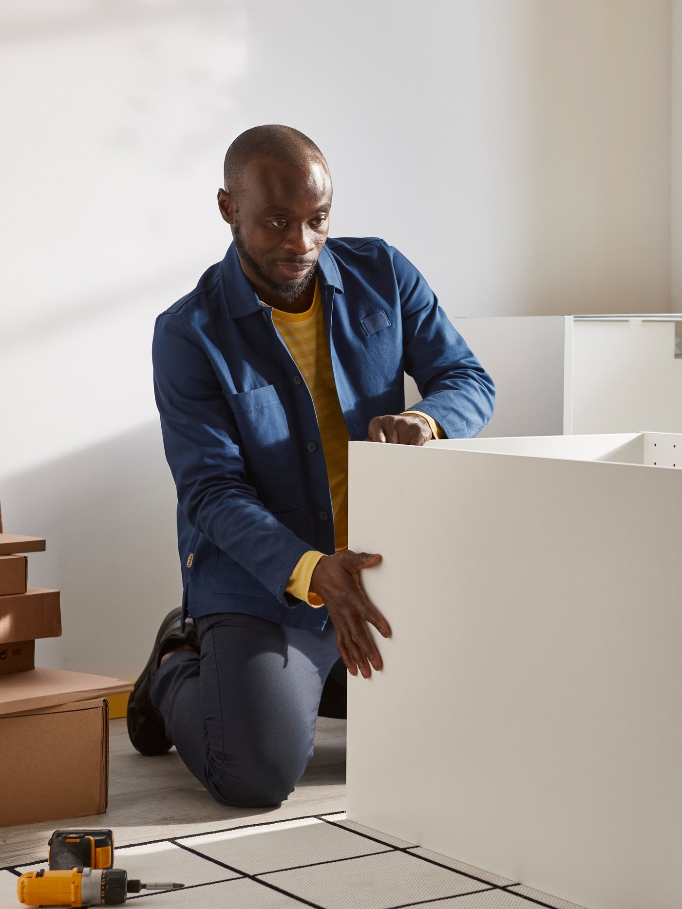 IKEA collaborateur qui assemble une armoire de cuisine blanche