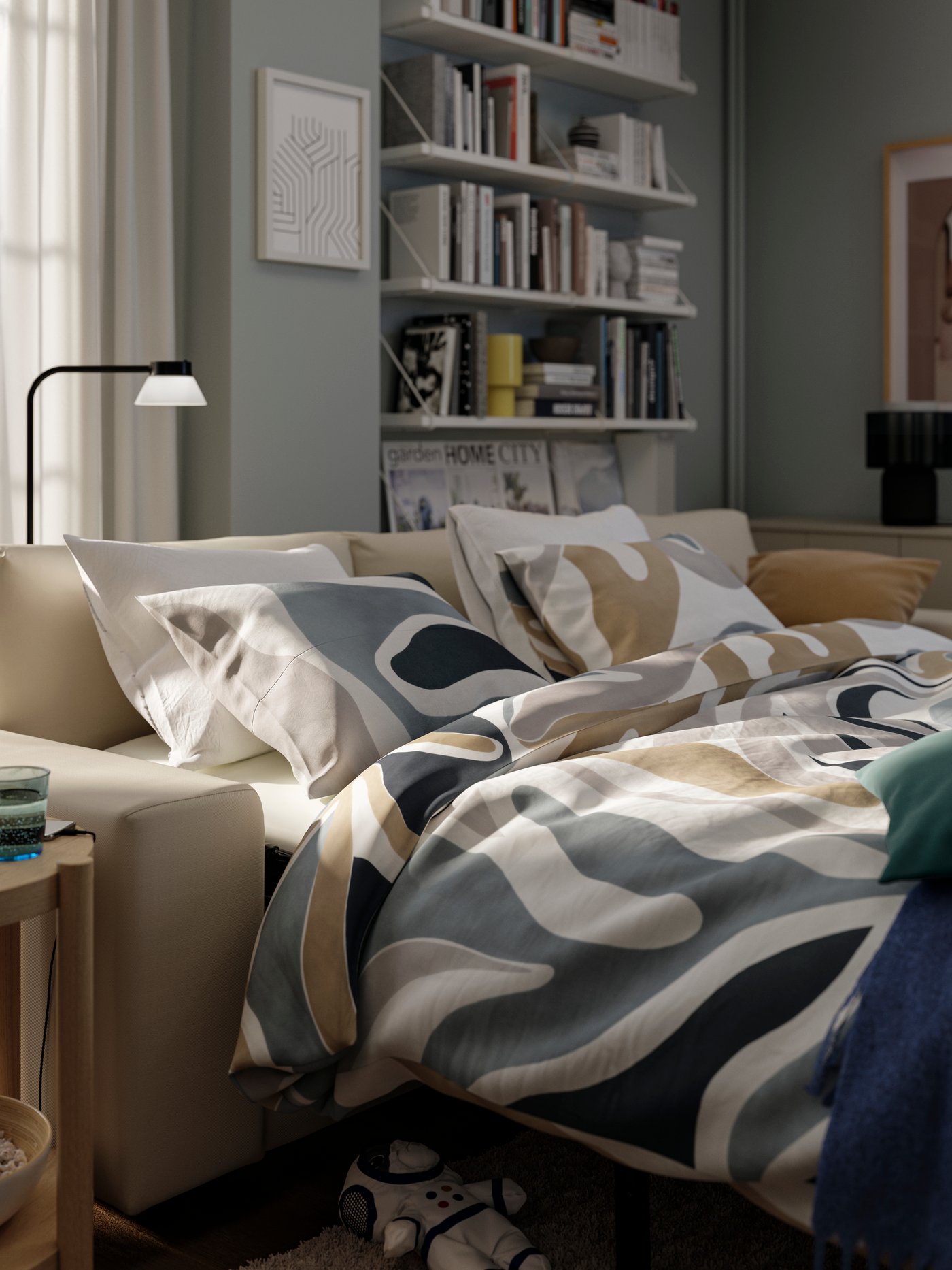 A VIMLE sofa-bed folded out as a handy and cosy double bed for overnight guests filled with MYGGLASVINGE bed textiles.
