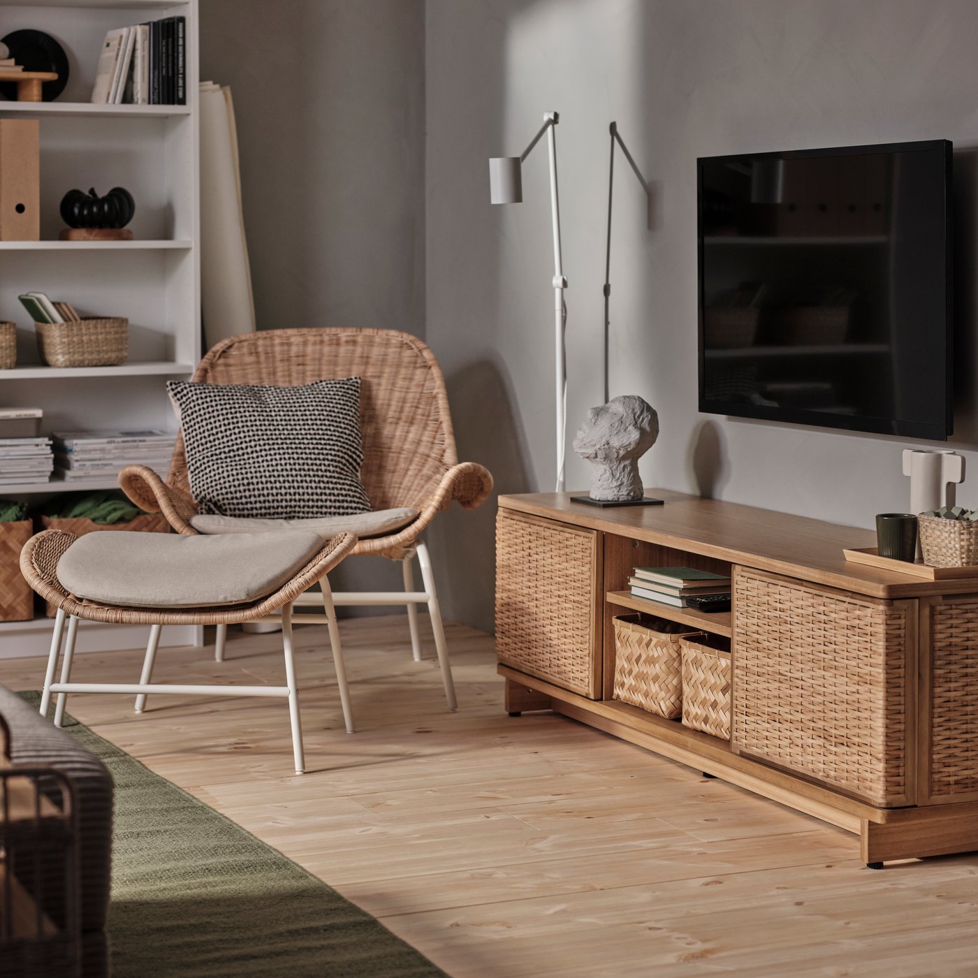 A rattan/Risane natural FRYKSÅS armchair with cushion in the living room