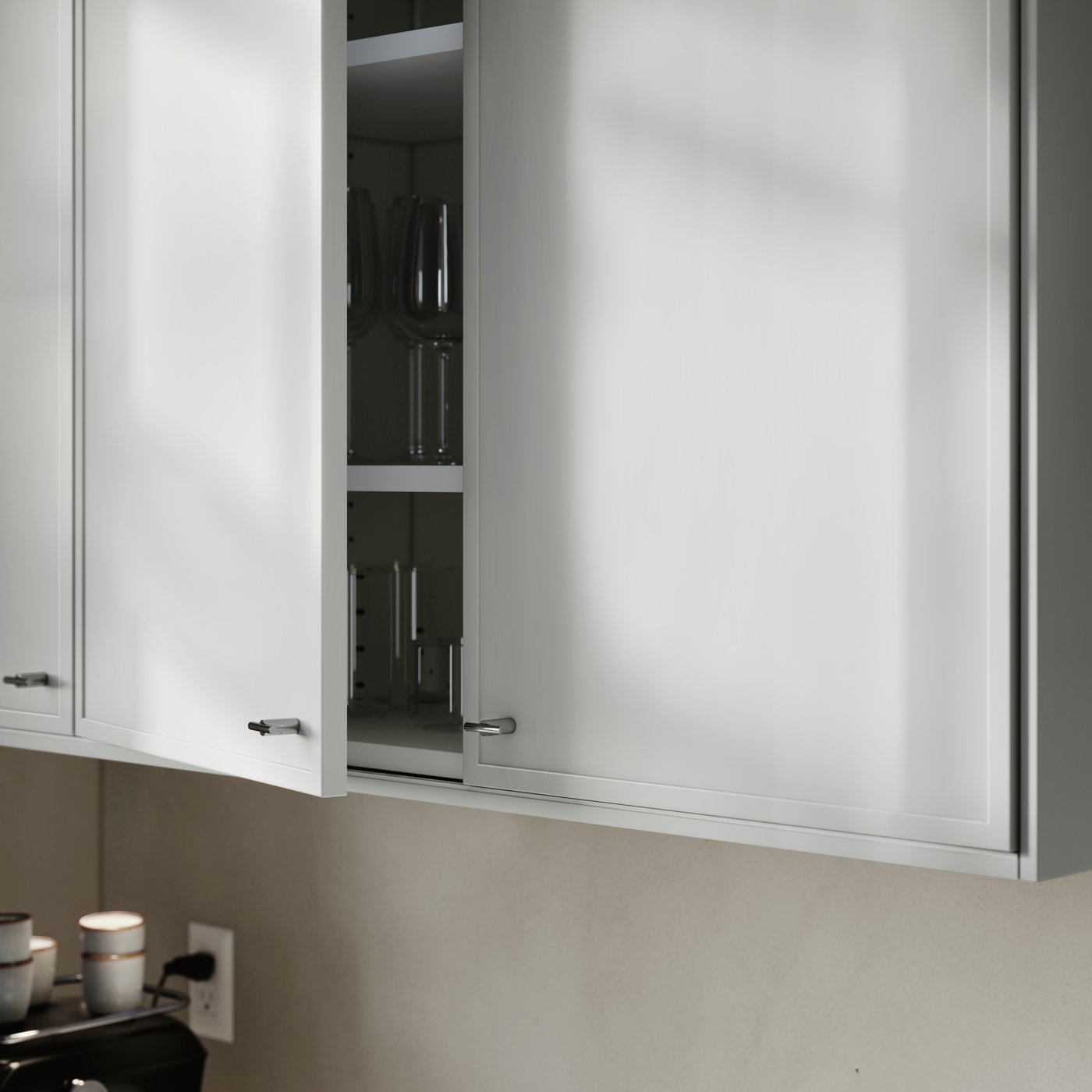 A kitchen cabinet with ASPUDDEN doors in light grey, one slightly open, showing drinking glasses and wine glasses inside.