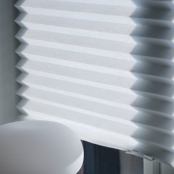A white SCHOTTIS pleated blind in the bedroom