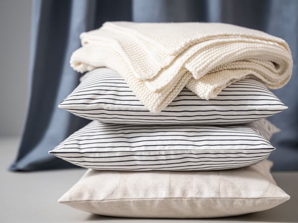 Two striped pillows and a light blanket