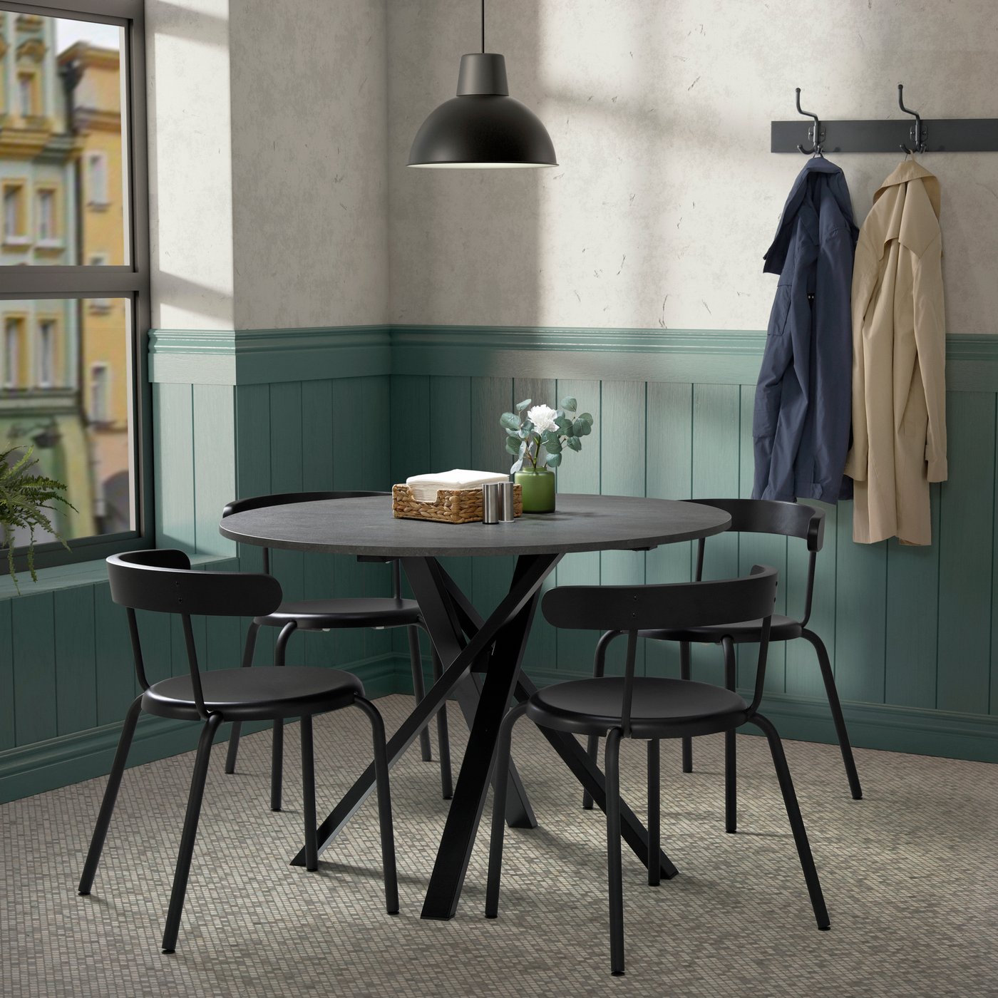 A small kitchen featuring a black kitchen table with chairs.