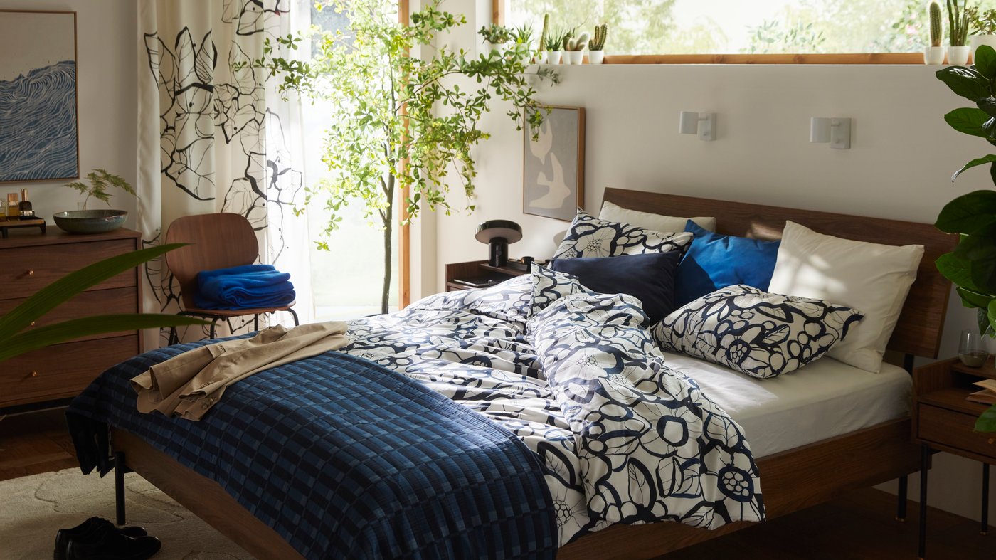 A dark blue SANELA cushion cover in the bedroom