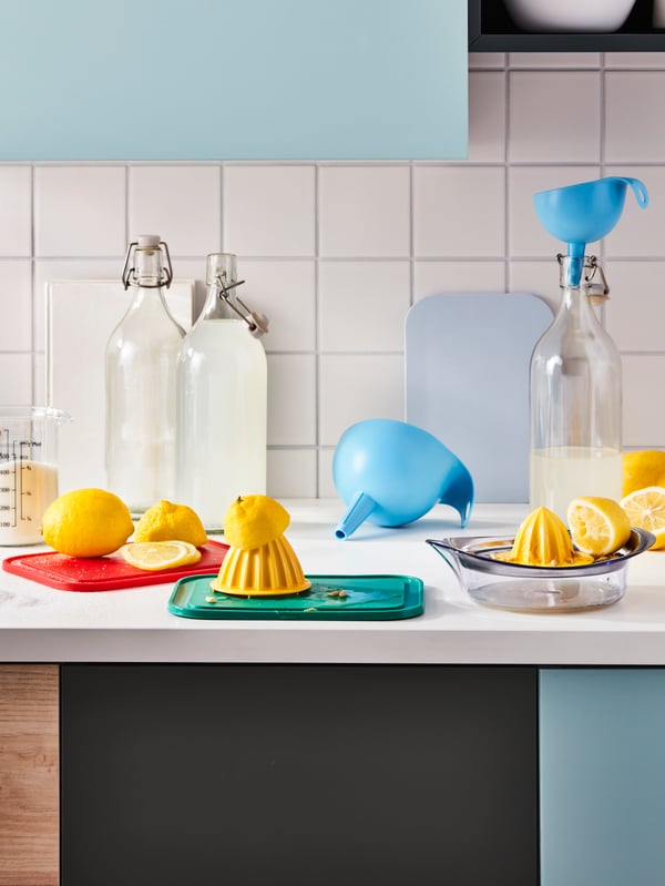 Permukaan kerja dapur di tengah sesi membuat lemonad; lemon, pemerah SPRITTA, corong CHOSIGT dan botol KORKEN.