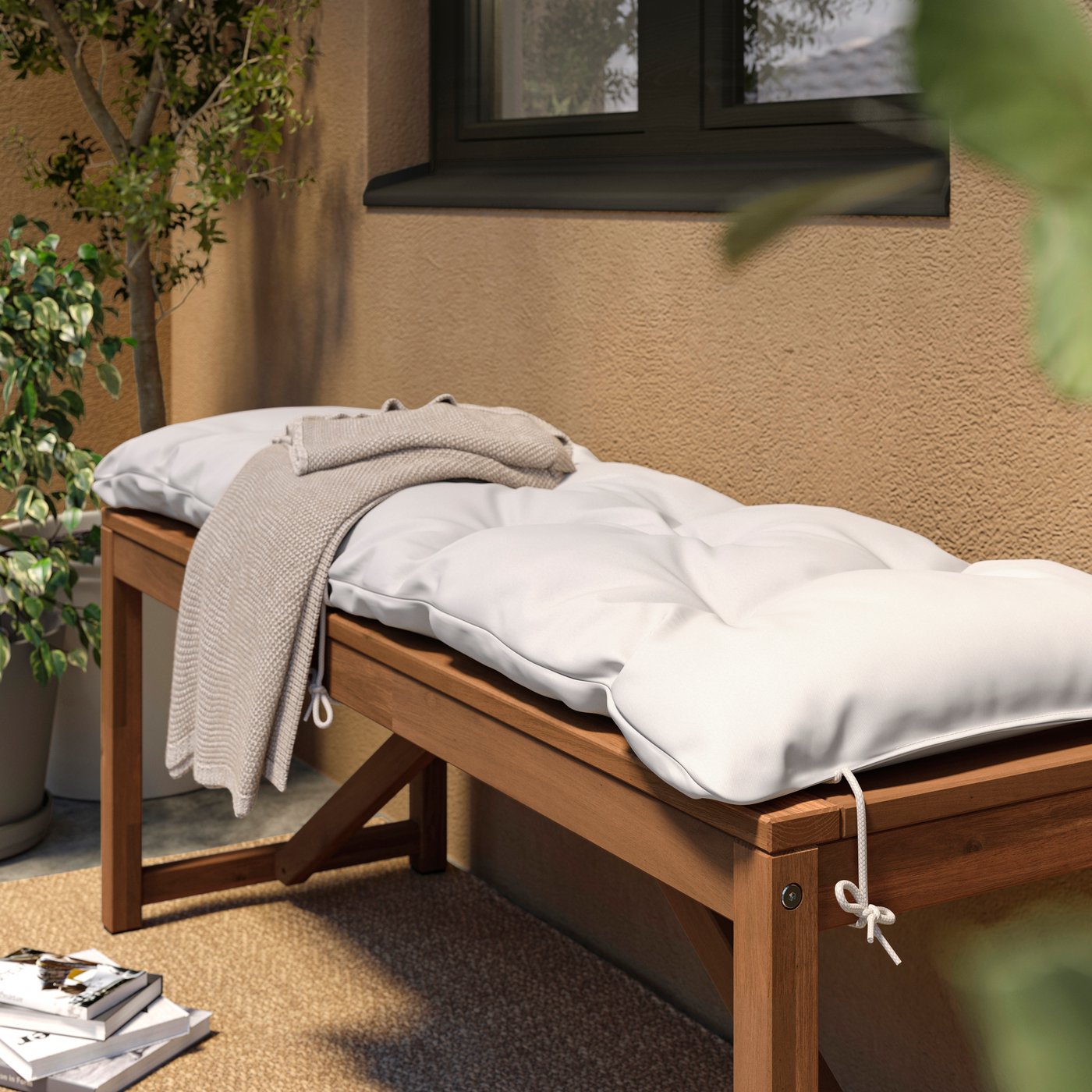 A wooden NÄMMARÖ garden bench with a KUDDARNA outdoor bench cushion on top.