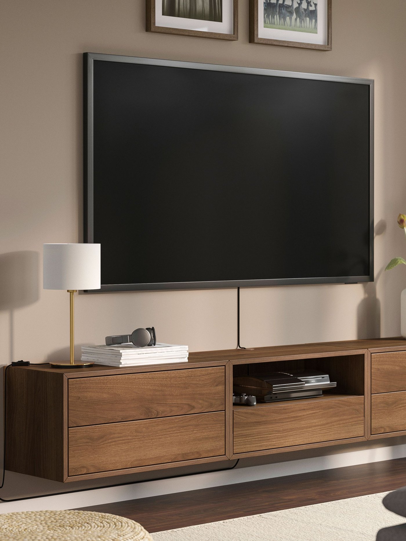 Vägghängd tv-bänk i valnöt på beige vää med vägghängd tv ovanför.