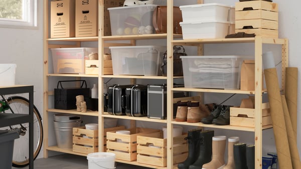 A wooden IVAR shelving unit in the garage or storage room with wooden KNAGGLIG storage boxes and plastic SAMLA containers filled with sports gear or other items.