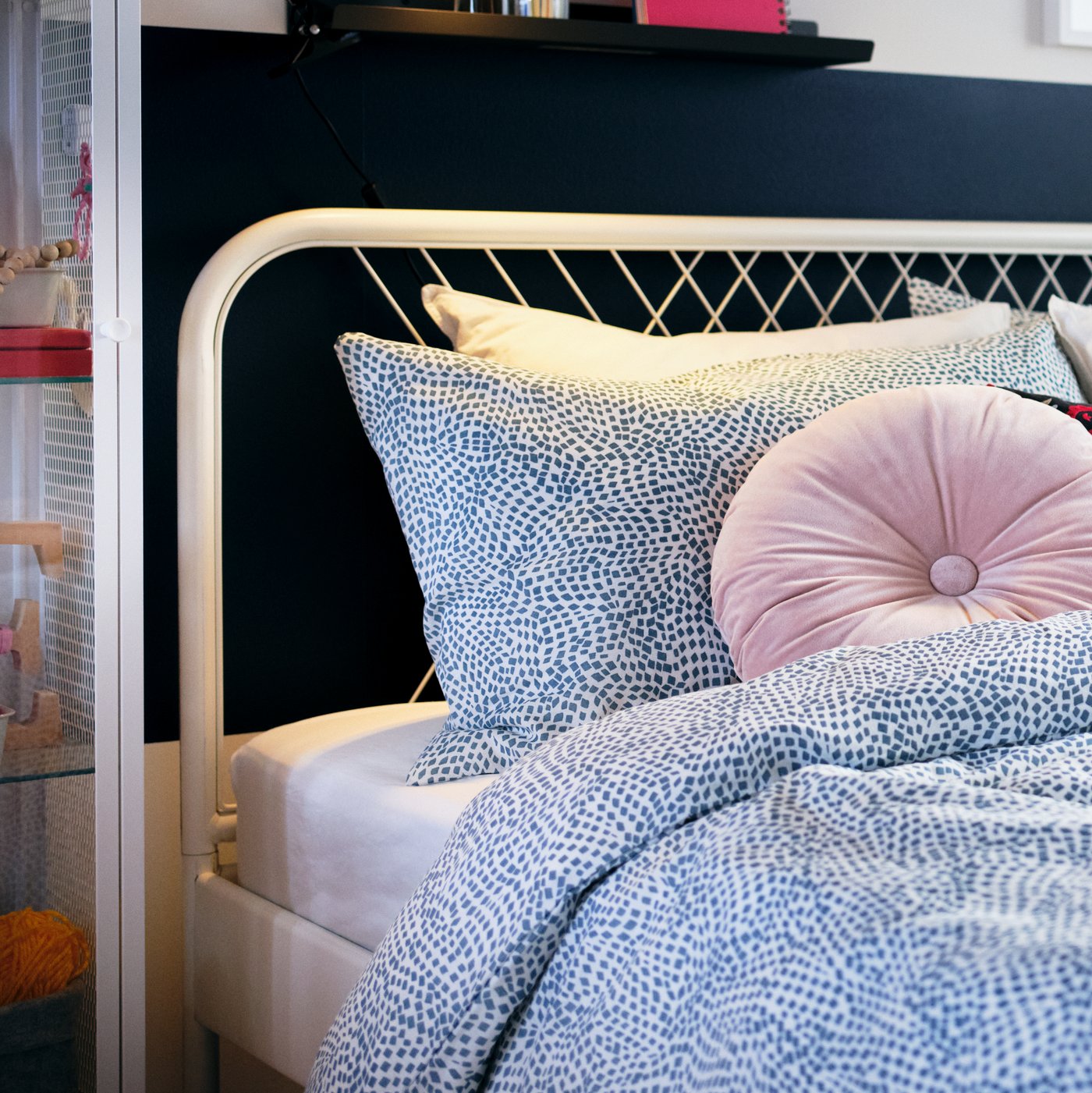 Cama con funda de plumón TRÄDKRASSULA color blanco con azul. Además se ve un cojín rosado.