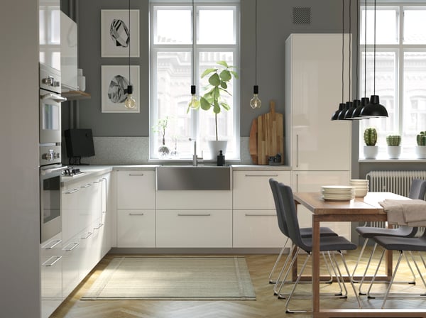 Moderne Küche mit weißen Hochglanzfronten, Edelstahl Spüle und grauen Wänden