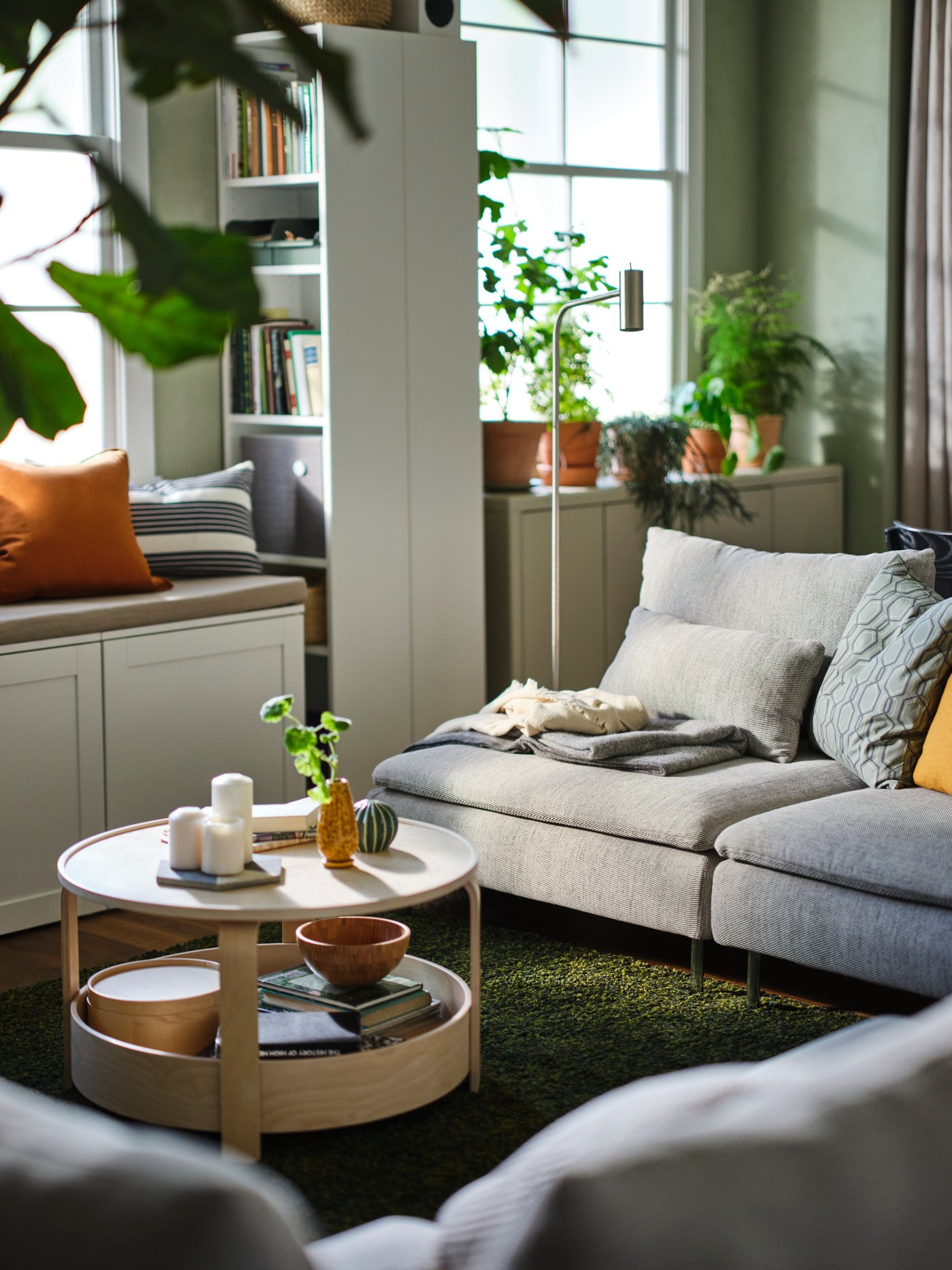 A living area with a white PLATSA storage bench and two SÖDERHAMN 3-seat sofas around a birch veneer BORGEBY coffee table.