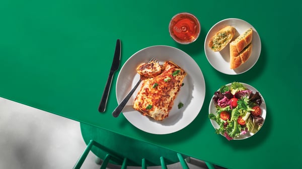 Lasagne, hvitløksbrød, salat og dispenserdrikke.