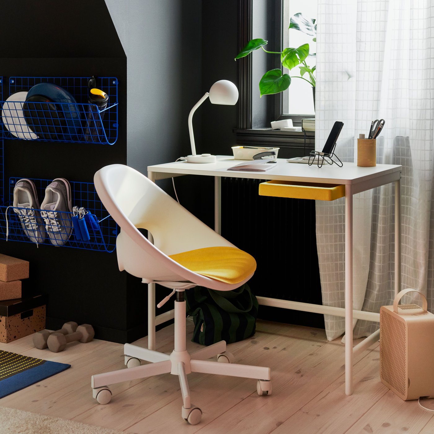 A slim white desk with a white‑and‑yellow desk chair in a child’s room.
