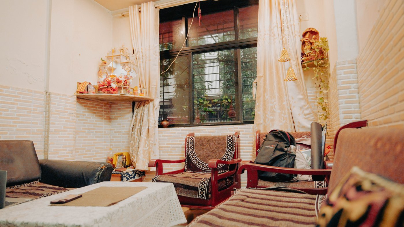 A room filled with interiors with a window and a garden outside.