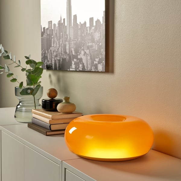 An orange glass/round VARMBLIXT LED table/wall lamp