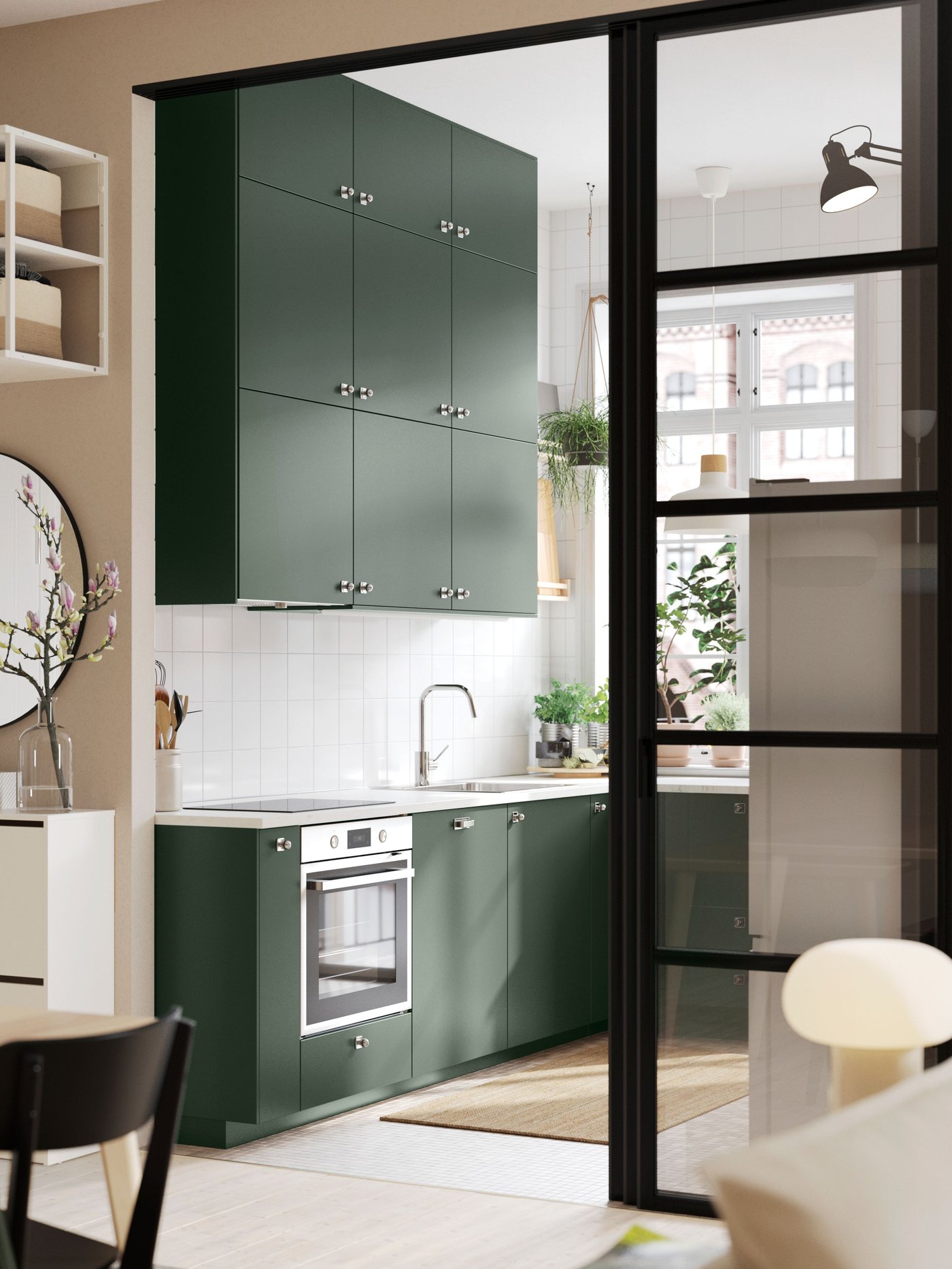 A wide doorway into a kitchen with deep green HAVSTORP kitchen fronts and a white marble effect/laminate EKBACKEN worktop.