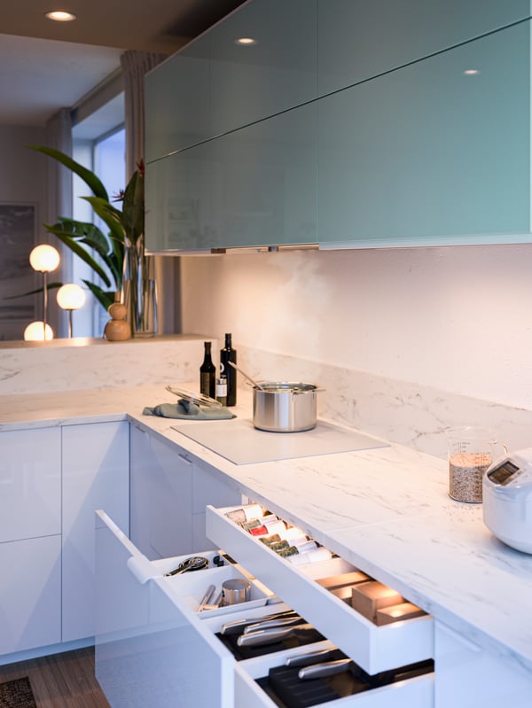 White marble effect/laminate worktop, open drawers with kitchen drawer light with sensor, spices and utensils.
