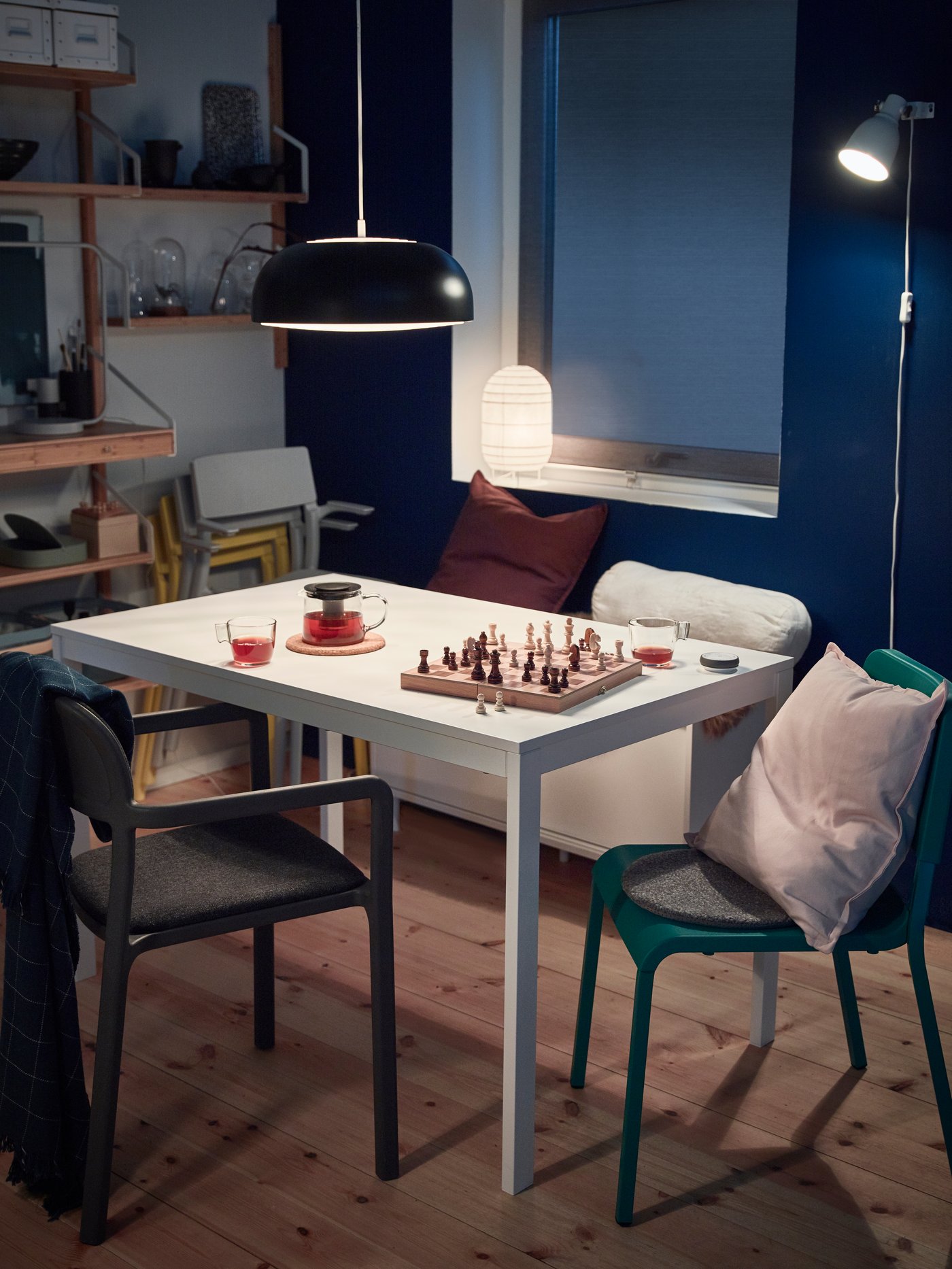 A small, white dining table surrounded by four TERJE white and light-grey chairs. An IDANÄS cabinet stands by a nearby wall.