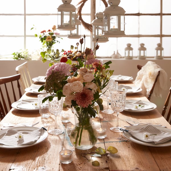 Mesa de boda tradicional con farolitos y un centro floral.