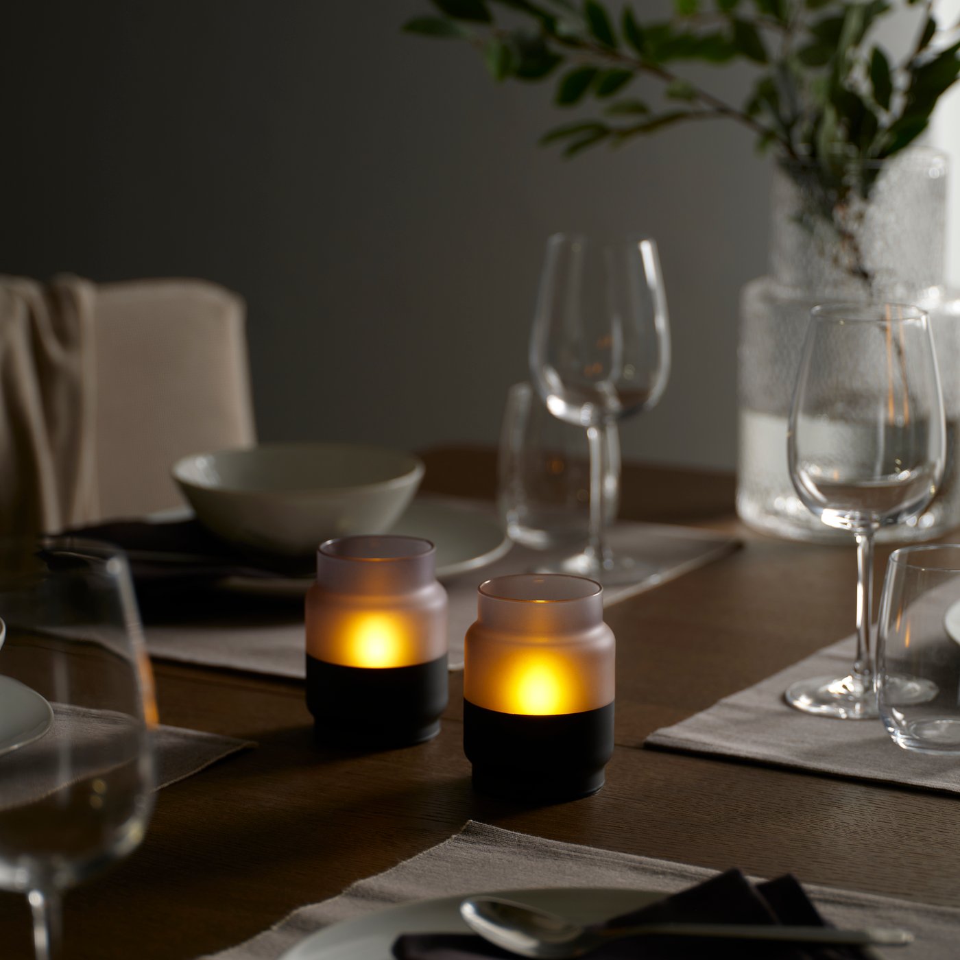 A glass/battery-operated greyish-black HJULMÖJA LED table decoration in the dining room