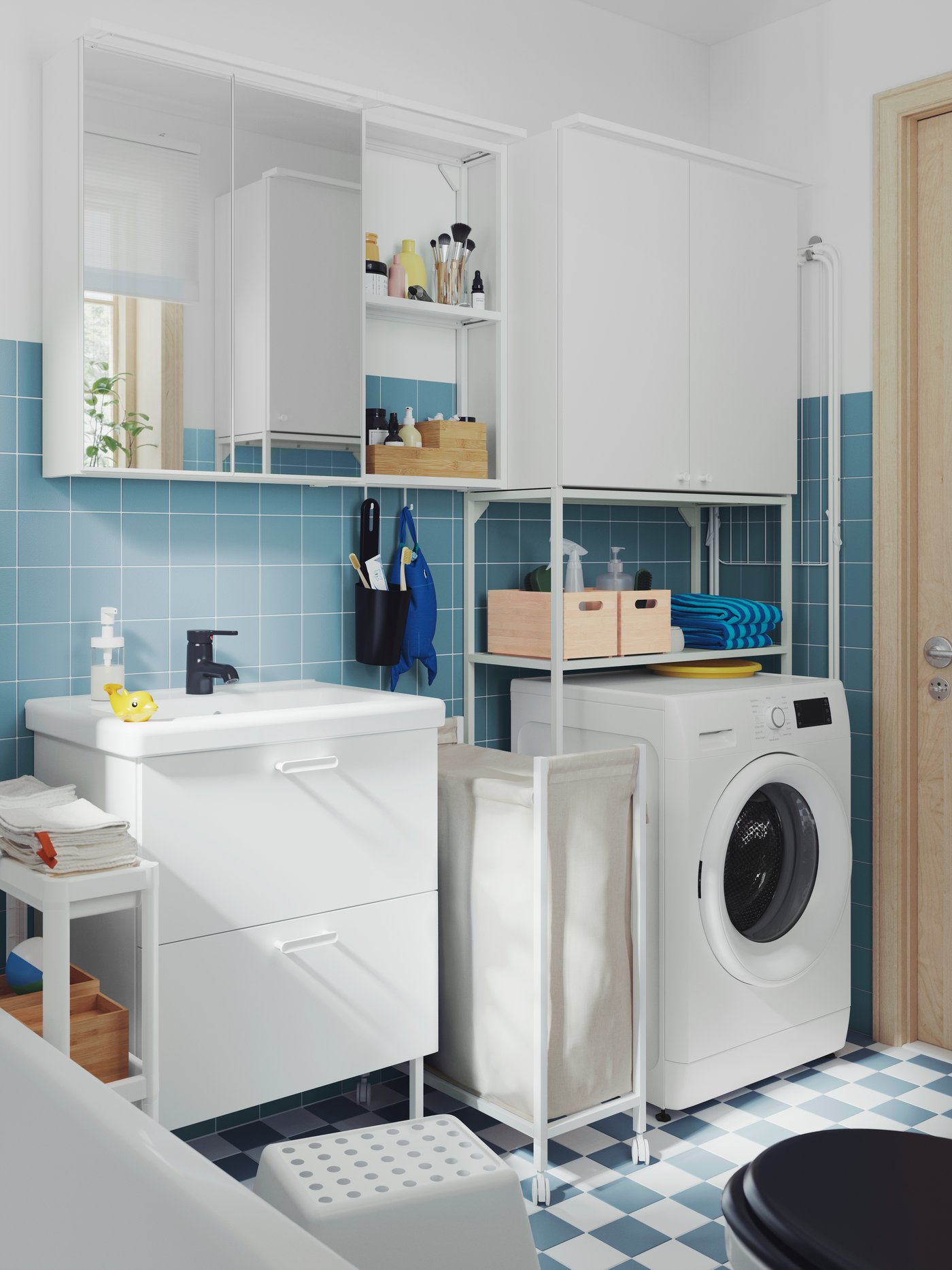 A small, blue-tiled bathroom has a white ENHET wash-stand, a mirror cabinet, a high cabinet and a white VESKEN trolley.