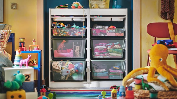 Una habitación infantil con muchos juguetes y muebles de almacenamiento TROFAST